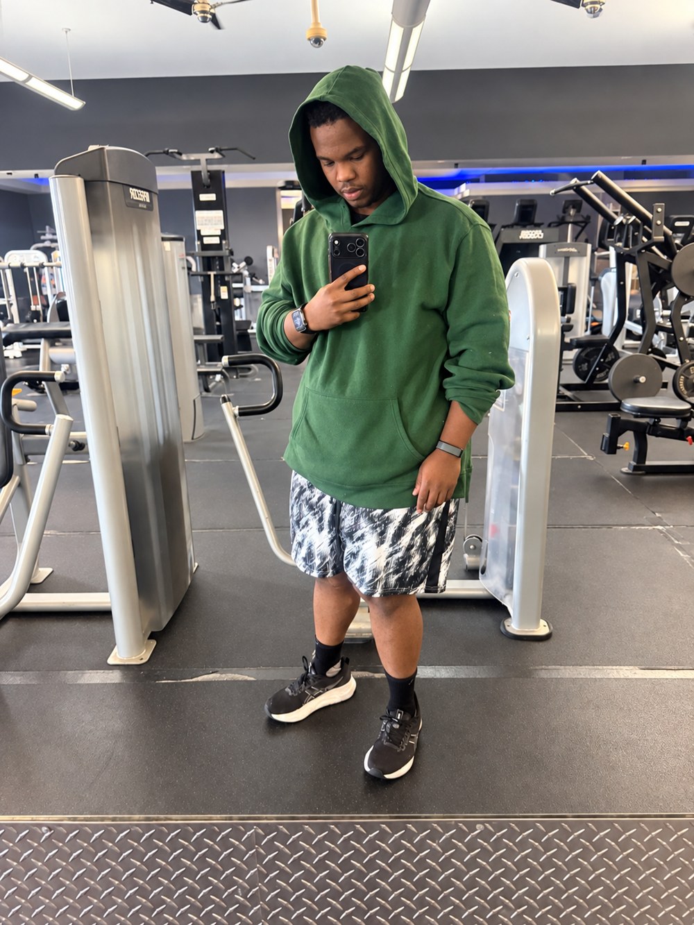 Devrin now, gym mirror selfie in a green hoodie